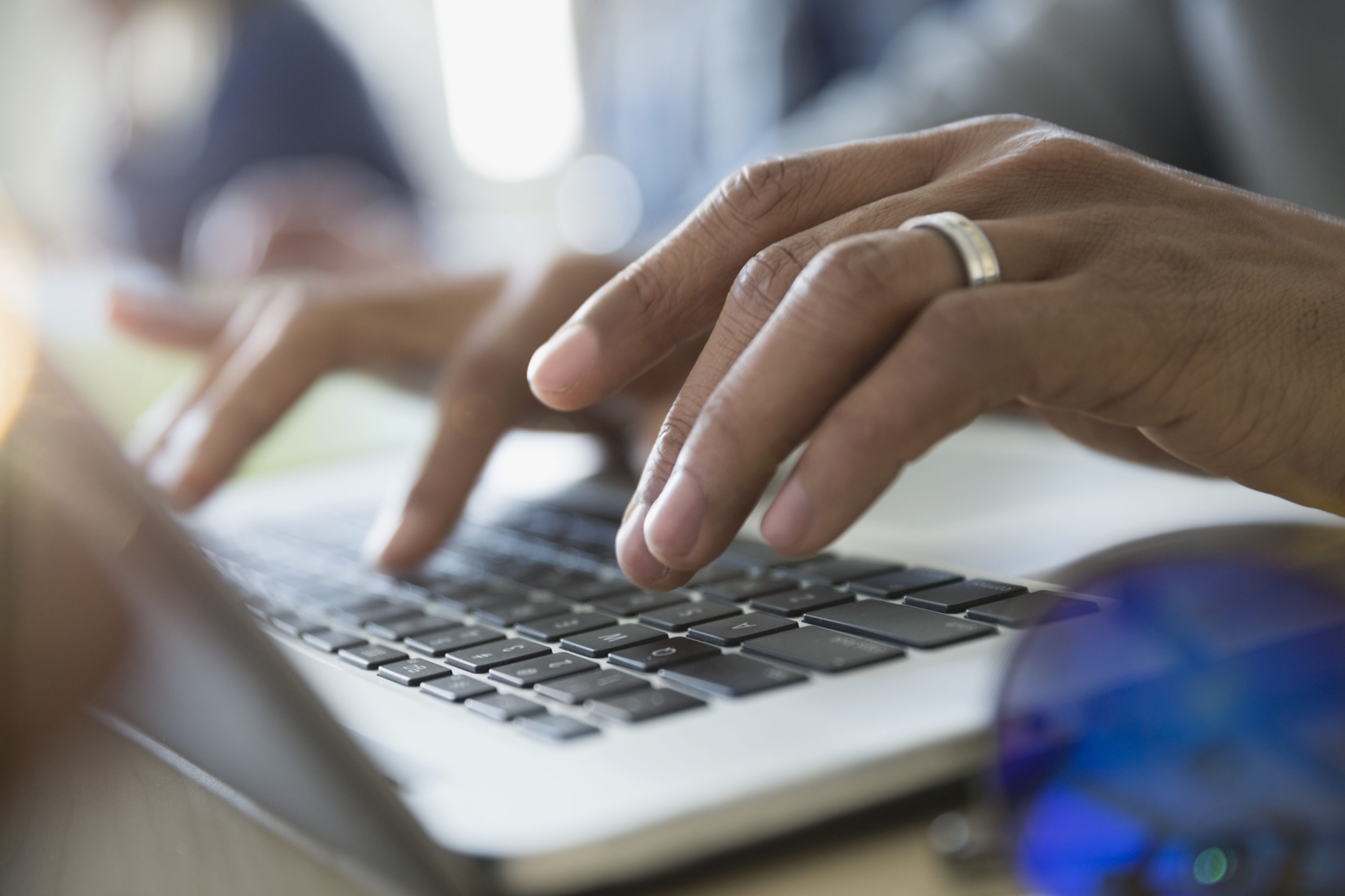 Close up adult education student typing on laptop